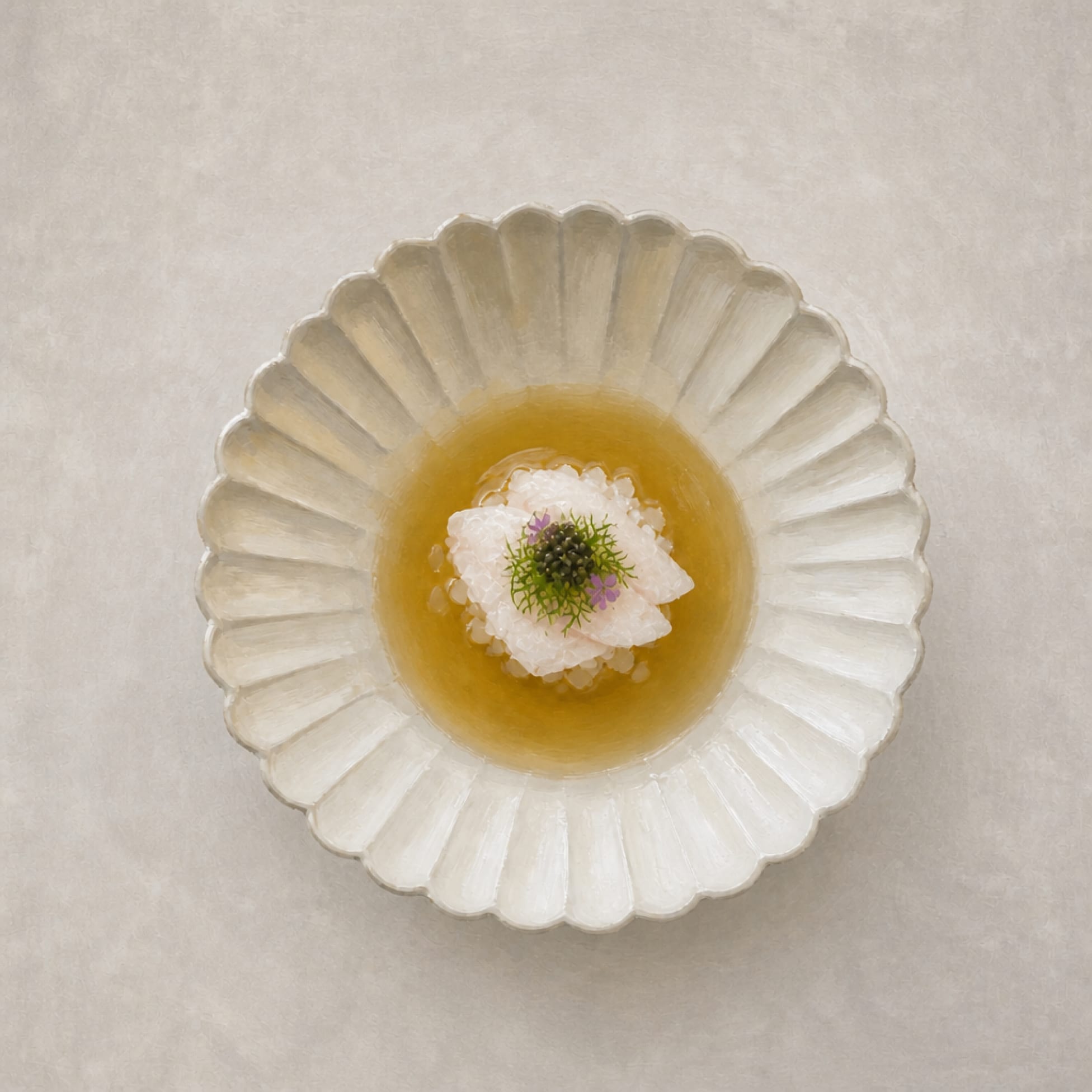 Illustration of a chilled seafood consommé topped with caviar and edible flowers